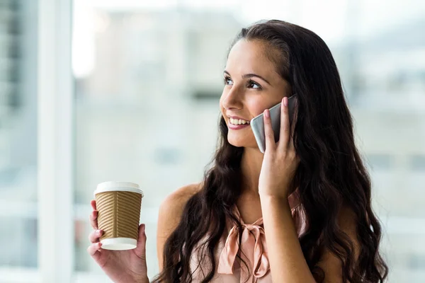 Mujer en la llamada telefónica sosteniendo taza desechable — Foto de Stock