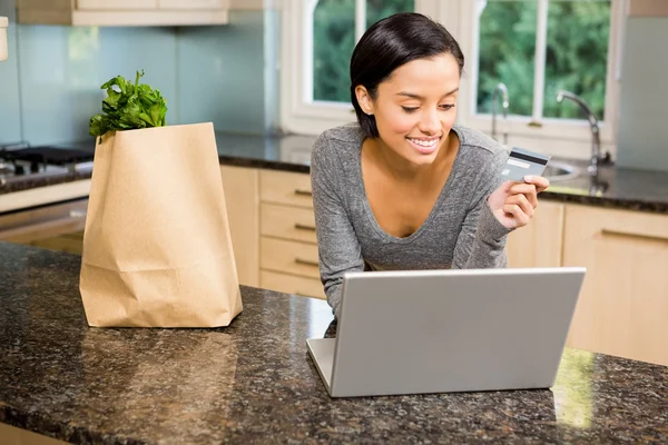 Brunette met laptop en creditcard bedrijf — Stockfoto