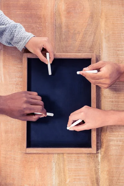 Hands of business people writing on slate — Stock Photo, Image