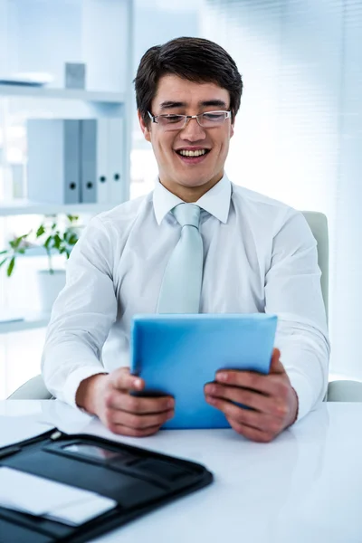 Lachende Aziatische zakenman met zijn tablet — Stockfoto