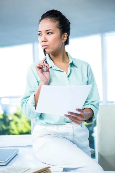 Femme d'affaires souriante assise sur son bureau — Photo