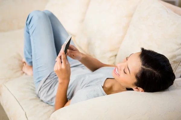 Lachende brunette met smartphone — Stockfoto