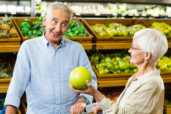 Casal sênior feliz procurando uma fruta — Fotografia de Stock