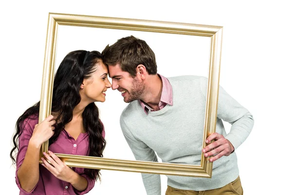 Feliz pareja sosteniendo marco de imagen —  Fotos de Stock