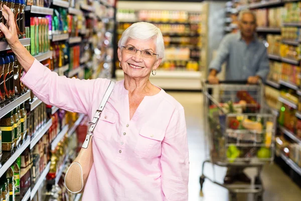 Senior woman picking out product — Stock Photo, Image
