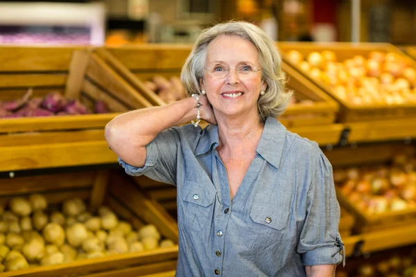 Mujer mayor sonriente en la tienda de comestibles — Foto de Stock