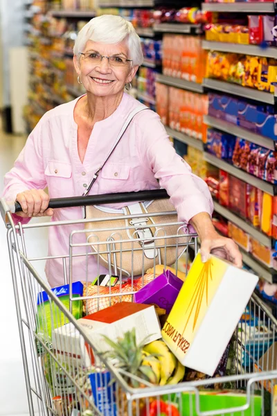 Lachende senior vrouw nemen cornflakes vak — Stockfoto