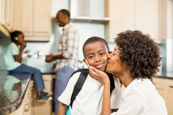 Moeder kussen zoon in de keuken — Stockfoto