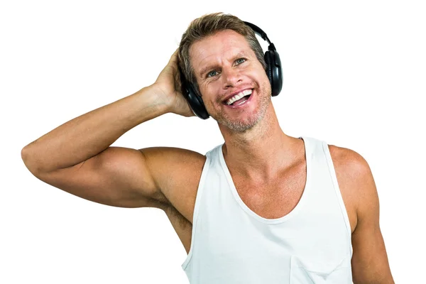 Smiling man hearing music from headphones — Stock Photo, Image