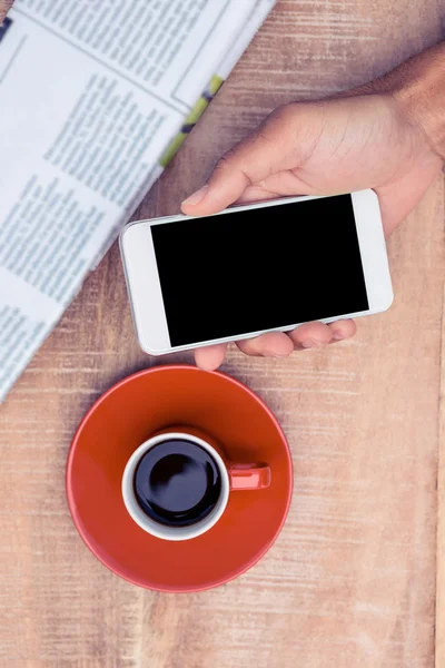 Persoon met behulp van smartphone door koffie — Stockfoto