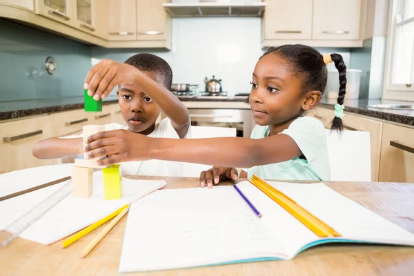 Děti dělají domácí úkoly v kuchyni — Stock fotografie