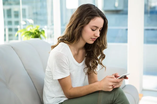 Mujer mensajes de texto en el sofá — Foto de Stock