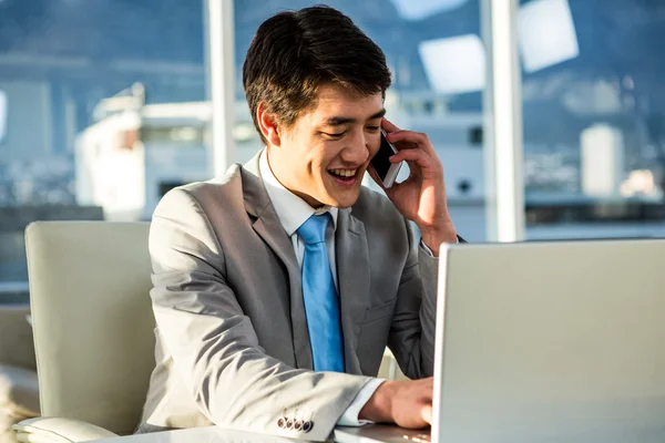 Усміхнений азіатський бізнесмен говорить по телефону — стокове фото