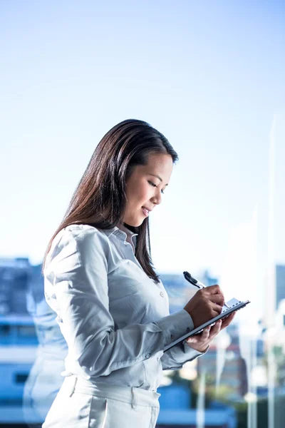 Lächelnde Geschäftsfrau schreibt auf Notizbuch — Stockfoto