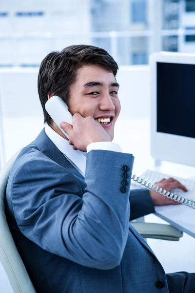 Sorrindo asiático empresário usando seu telefone — Fotografia de Stock