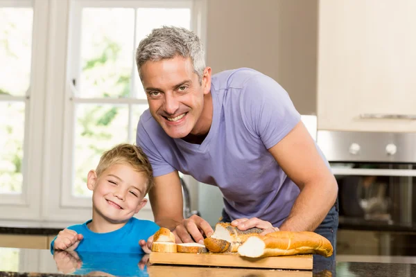 Happy father slicing bread — Stock Photo, Image