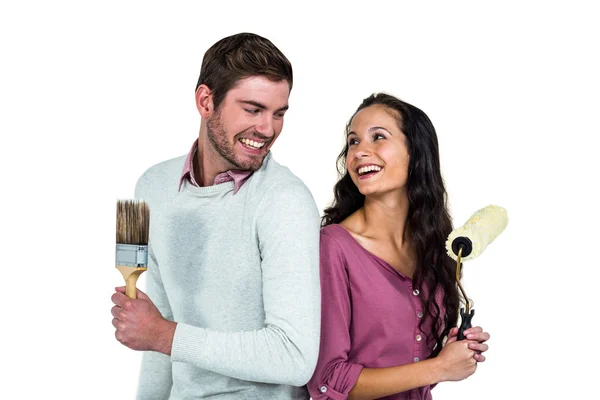 Smiling couple holding brushes — Stock Photo, Image