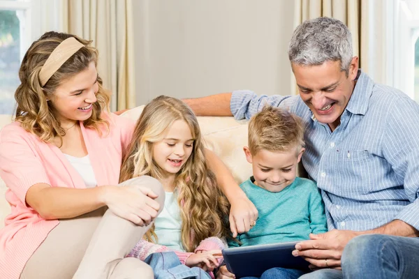 Familj med tabletten i soffan — Stockfoto