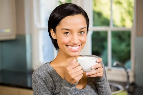 Usměvavá brunetka drží bílý hrnek — Stock fotografie