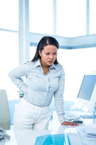 Stirnrunzeln bei Geschäftsfrau mit Rückenschmerzen — Stockfoto