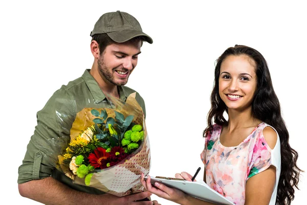 Woman signing for bouquet delivery — Stock Photo, Image