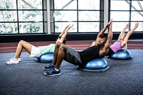 Fit people doing exercise with bosu ball — Stock Photo, Image
