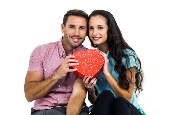 Retrato de pareja sonriente sosteniendo caja en forma de corazón —  Fotos de Stock