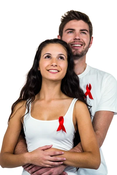 Sorrindo abraço casal com fitas vermelhas — Fotografia de Stock