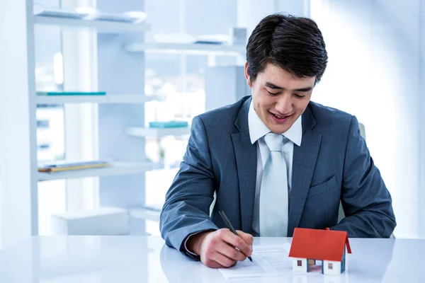 Sorridente uomo d'affari asiatico leggere un contratto immobiliare — Foto Stock