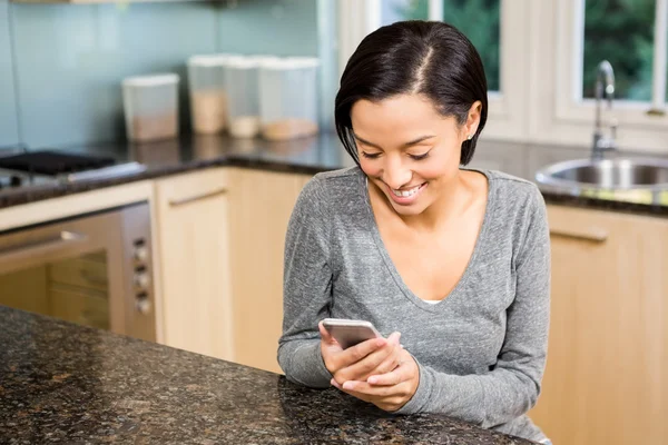 Usměvavá brunetka pomocí smartphone — Stock fotografie