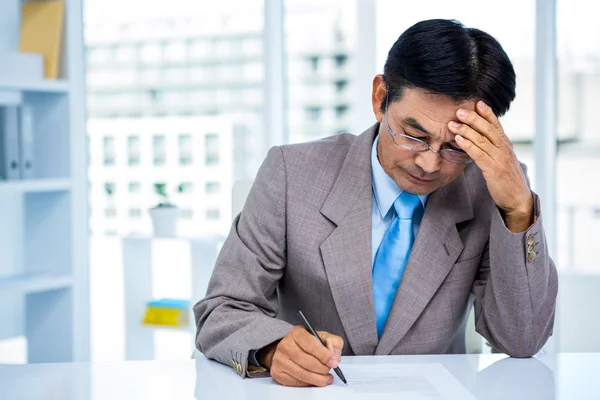 Preoccupato asiatico uomo d'affari sulla sua scrivania — Foto Stock