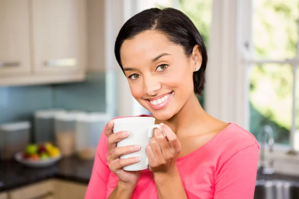 Uśmiechający się brunetka trzymając kubek biały — Zdjęcie stockowe