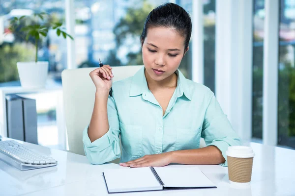 Pensativo joven mujer de negocios buscando notas —  Fotos de Stock