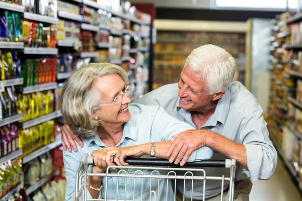 Casal sênior feliz com carrinho — Fotografia de Stock