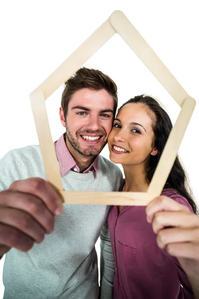 Casal sorrindo segurando a forma da casa — Fotografia de Stock