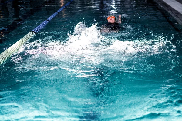 Fitte Frau schwimmt mit Badehut — Stockfoto