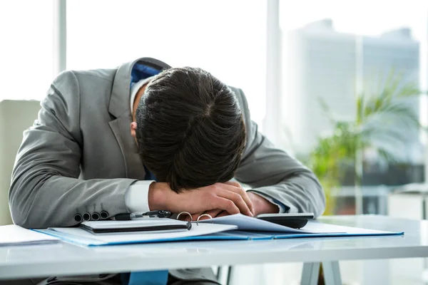 Homme d'affaires allongé sur son bureau — Photo