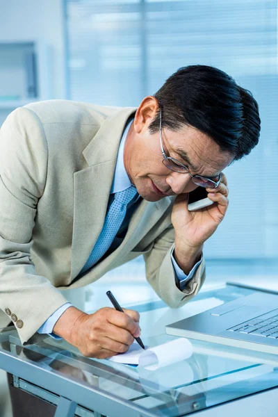 Asian businessman answering the phone — Stock Photo, Image