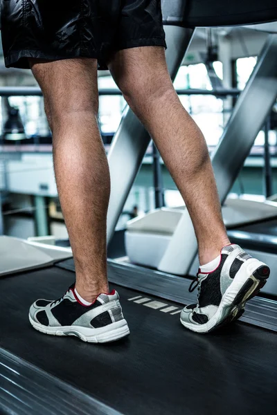 Muscular man using treadmill — Stock Photo, Image