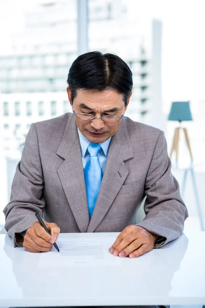 Serious businessman on his desk — Stock Photo, Image