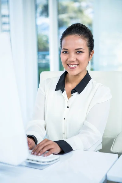 Smiling businesswoman typing — Stock Photo, Image
