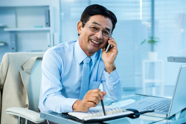 Lächelnder asiatischer Geschäftsmann ruft jemanden an — Stockfoto