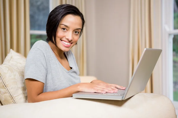 Smiling brunette using laptop — Stock Photo, Image