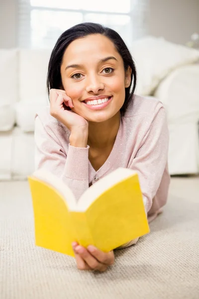 Smiling brunette reading book Royalty Free Stock Photos