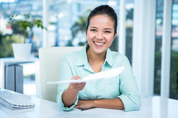 Empresária sorridente mostrando um papel — Fotografia de Stock