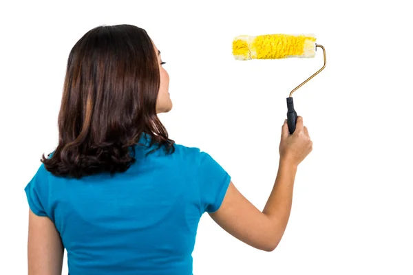 Vista trasera de la mujer sosteniendo rodillo de pintura —  Fotos de Stock