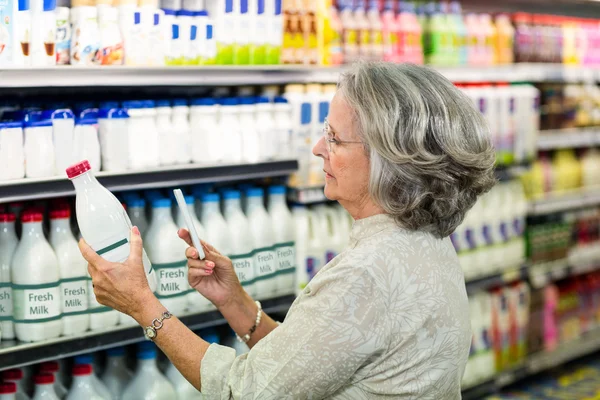 Vezető nő figyelembe képet a tej-palack — Stock Fotó