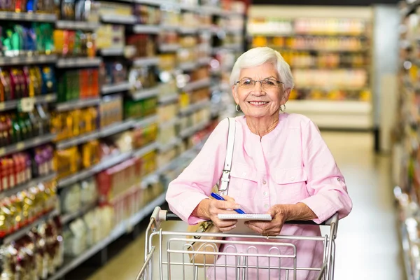 Mujer mayor sonriente con lista de supermercados —  Fotos de Stock