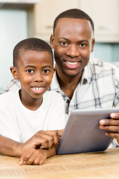 Pai e filho usando tablet juntos — Fotografia de Stock