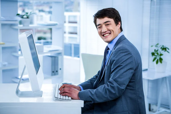 Homme d'affaires souriant utilisant son ordinateur — Photo